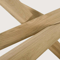 Close-up of solid natural oak wood legs of Ethnicraft Mikado Oval dining table showcasing its smooth finish and craftsmanship