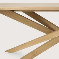 Close-up of Ethnicraft Mikado Oval Dining Table solid natural oak base with intersecting angled legs