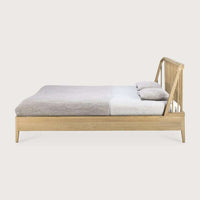 Side view of Ethnicraft Spindle Bed in natural oak with spindle design headboard and tapered legs