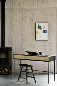 Ethnicraft Blackbird console desk in natural oak and black with slim metal legs and two soft-close drawers in modern room setting