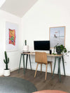 Newport Hoops Print framed wall art above minimalist desk with wooden chair and indoor plants in modern room