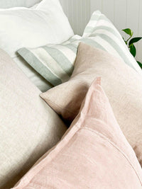 norsu Studio Washable Cushion in blush with soft fabric and machine washable design on a sofa with striped and neutral cushions