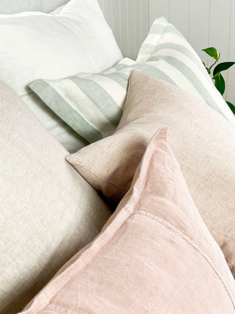 norsu Studio Washable Cushion in blush with soft fabric and machine washable design on a sofa with striped and neutral cushions