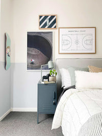 Slate grey Mustard Made Locker with handle and lock beside a bed in a modern bedroom setting