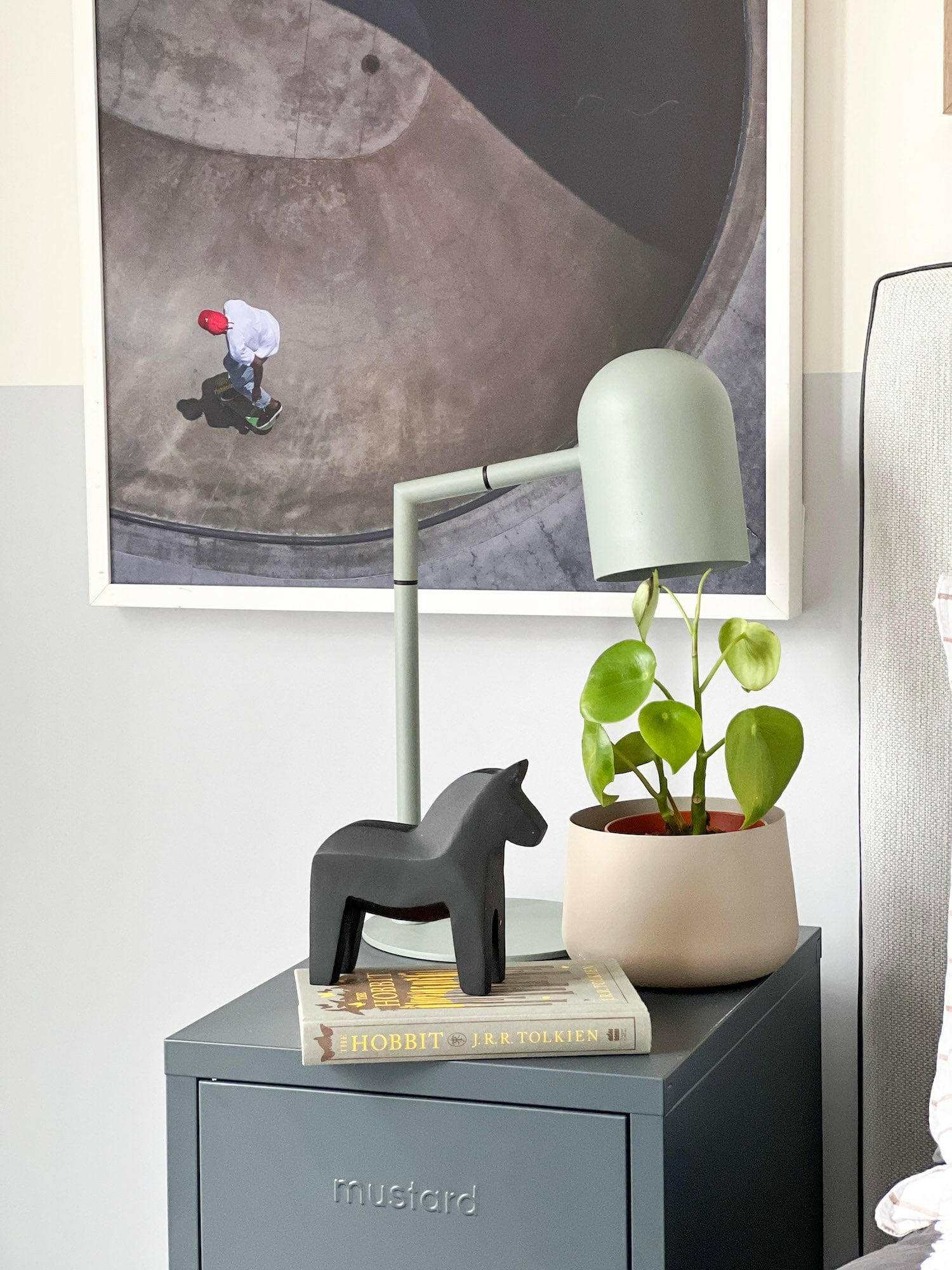 Pia desk lamp in sage green with modern architectural design on a bedside table.