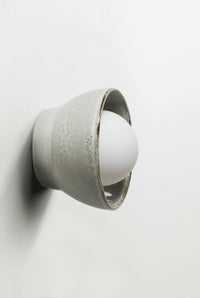Robert Gordon Bowl Sconce ceramic wall light with halogen globe in saltbush finish mounted on white wall