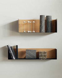 Ethnicraft Black Oak U Shelf with solid oak back and black metal frame mounted on wall with decorative objects and books
