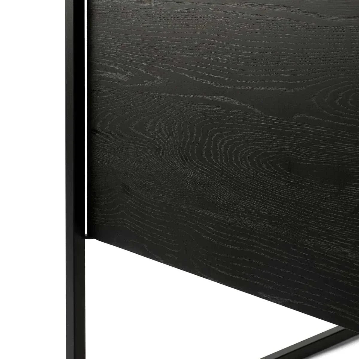 Close-up of black tainted solid oak wood grain and black metal frame of Ethnicraft Oak Monolit sideboard.