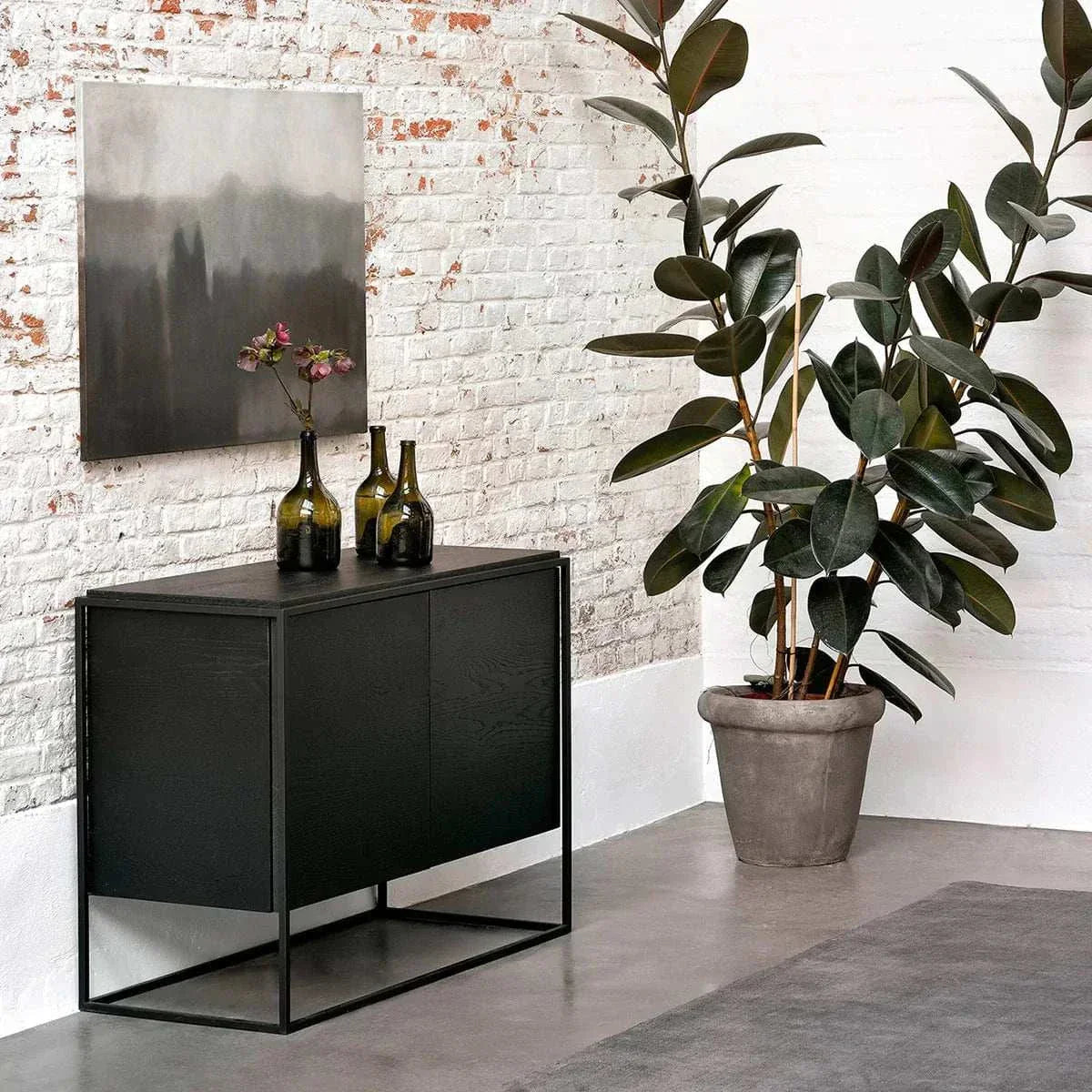 Black Ethnicraft Oak Monolit sideboard with two doors and metal frame in modern interior setting