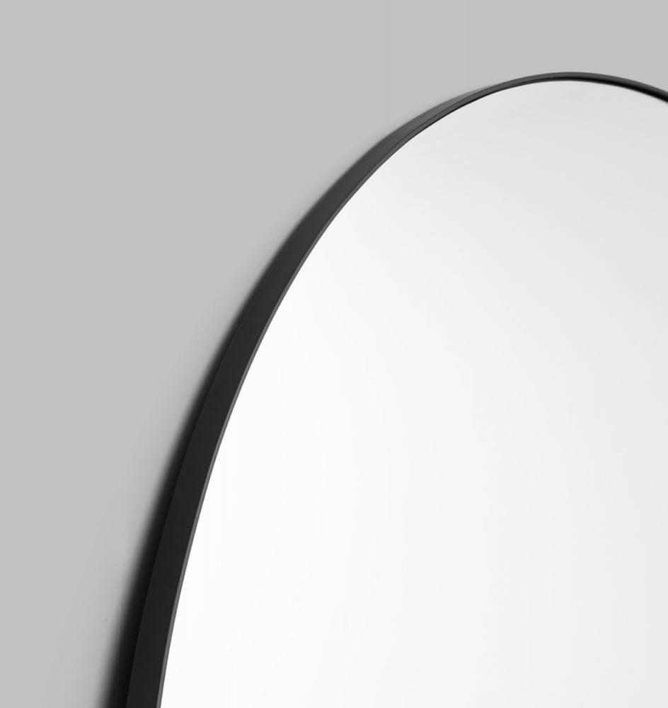 Close-up of Middle of Nowhere Bjorn Arch oversized mirror with slim black frame on gray wall
