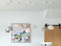Set of large ceramic Robert Gordon Bell Light pendant lamps in neutral tones hanging from ceiling in modern room with artwork and wooden door