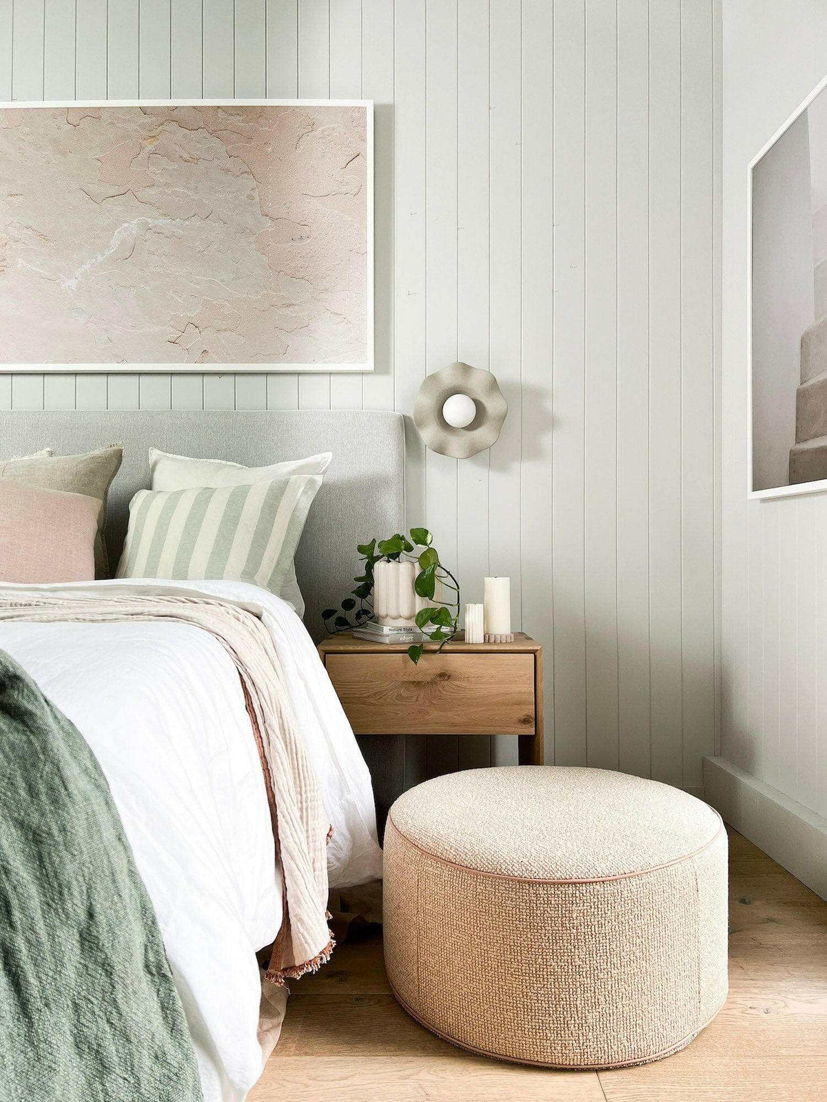 Ethnicraft Nordic Oak Bedside Table with drawer in a modern bedroom setting next to a bed and round upholstered stool
