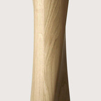 Close-up of the twisted oak wooden base of the Ethnicraft Oak Torsion dining table with a varnished finish