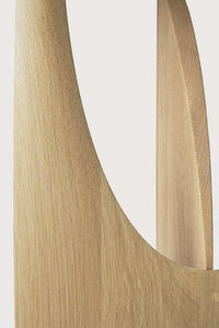 Close-up of Ethnicraft oak geometric side table showing varnished solid wood texture and clean intersecting shapes