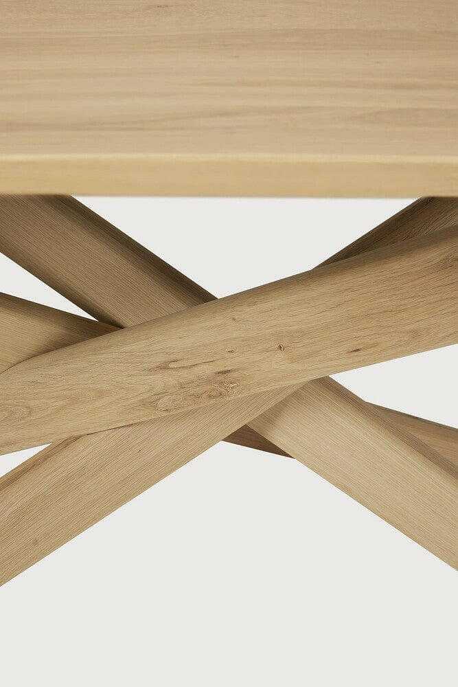 Close-up of the solid European Oak natural finish Ethnicraft Dining Table Mikado showing the inward flowing interlocking legs design.