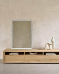 Ethnicraft Shadow TV Stand in natural oak with clean lines and low profile design featuring drawers and open shelves.