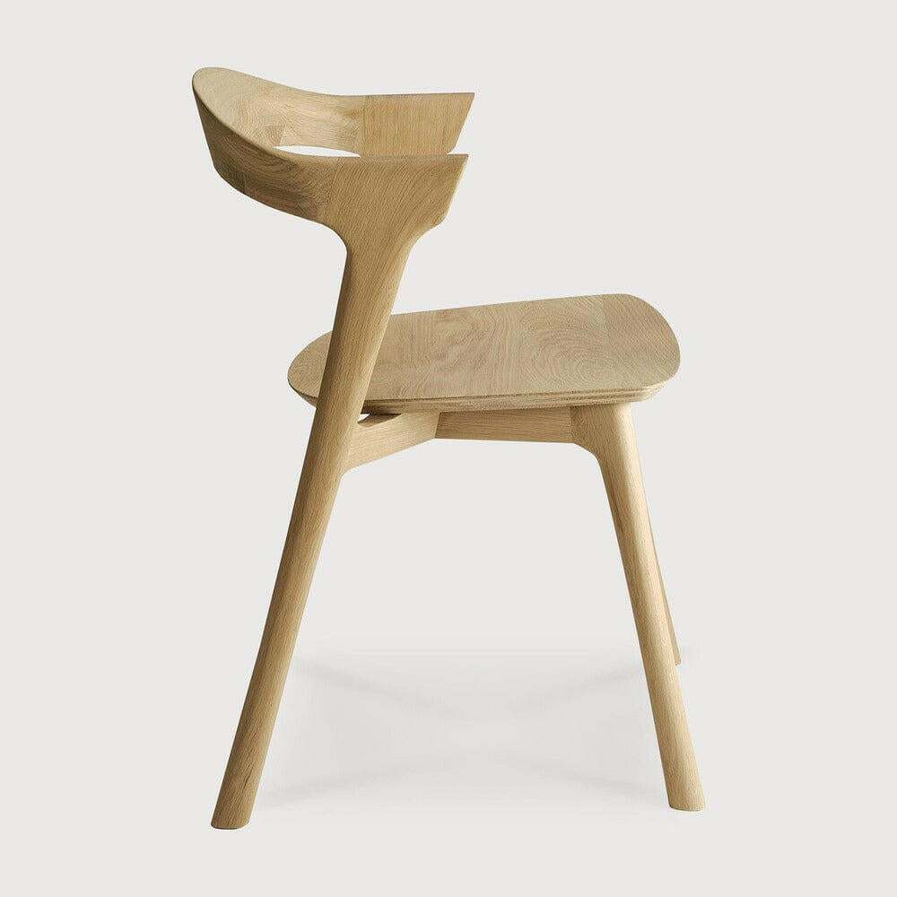 Side view of Ethnicraft Bok Dining Chair made of natural oak with sculptural curved backrest and minimalist modern design