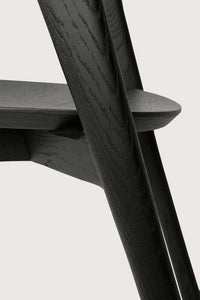 Close-up of black Ethnicraft Bok Dining Chair made from solid European oak with sleek, sculptural design.