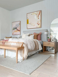 Jen Sievers Limited Edition fine art canvas print hung above a modern bedroom bed with neutral tones and wooden bench.