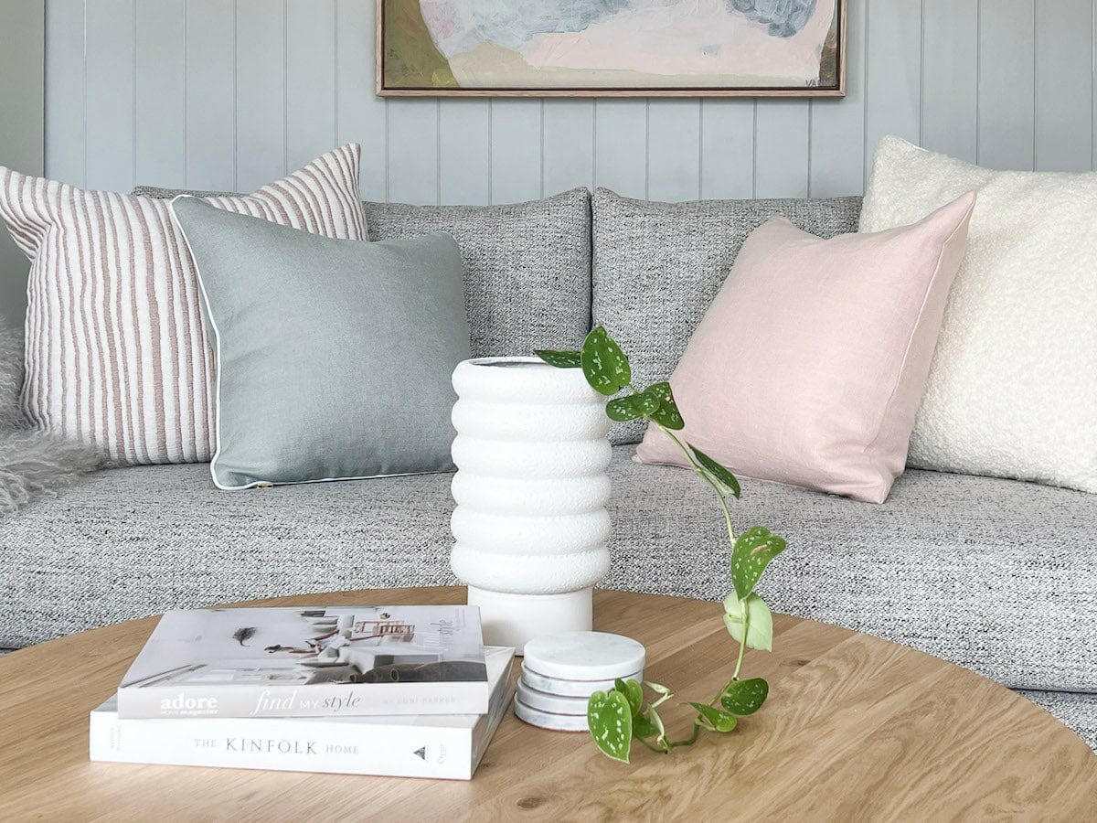 White textured bubbly Alder Pot planter in white porcelain on wooden coffee table with trailing green plant and stacked books in modern living room