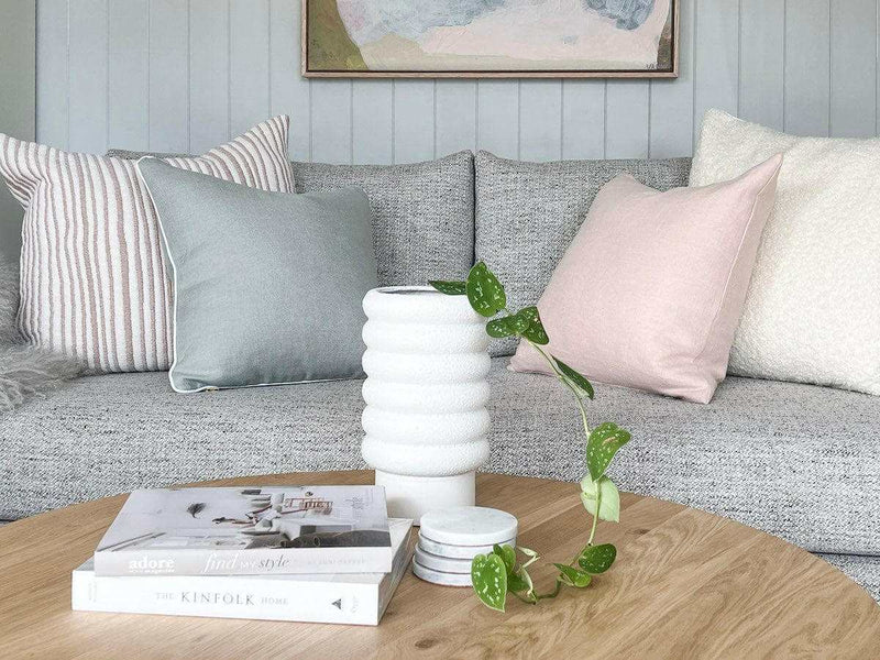 White textured bubbly Alder Pot planter in white porcelain on wooden coffee table with trailing green plant and stacked books in modern living room