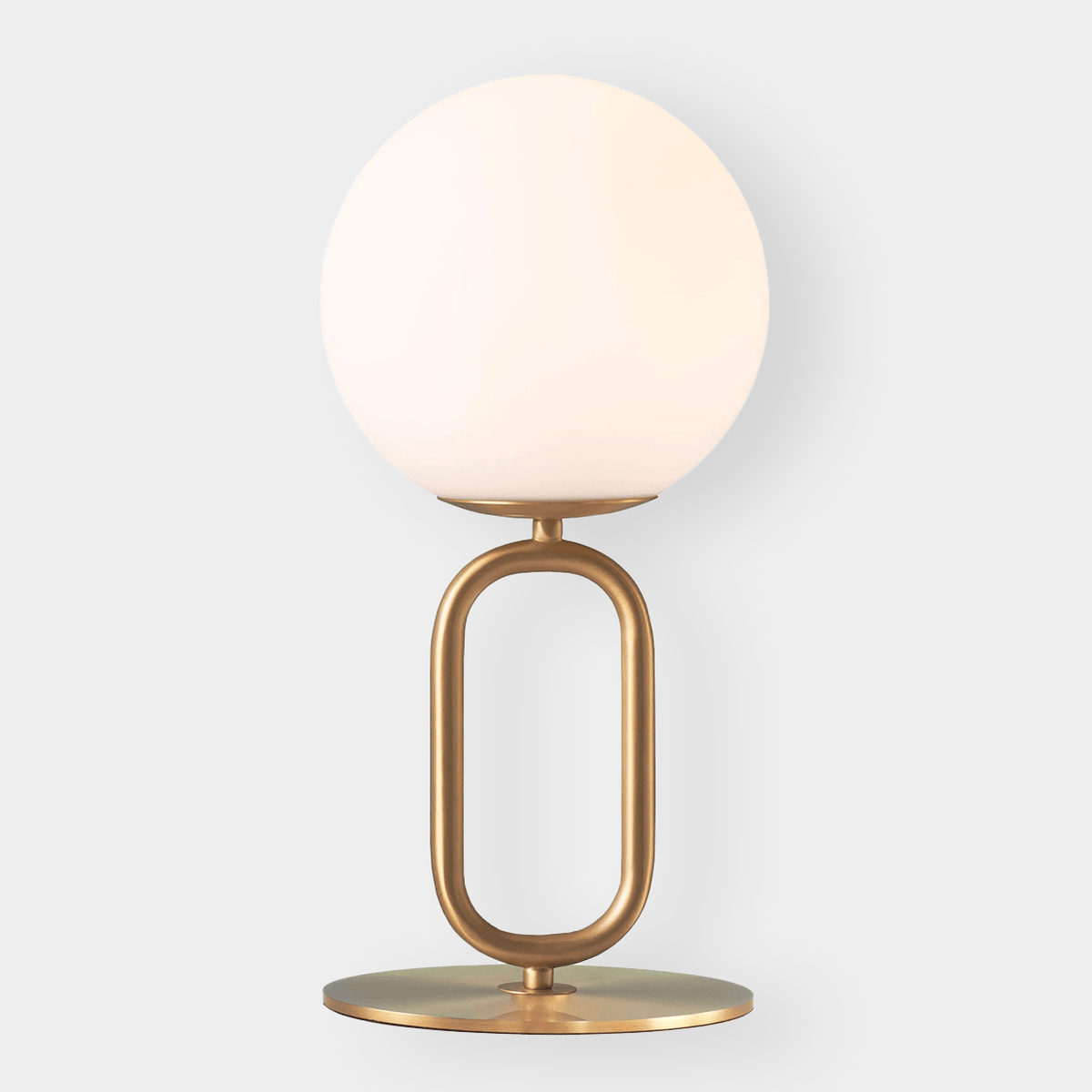 Modern brass desk lamp with frosted glass shade and oval base, elegant ambient lighting for workspace or living room.