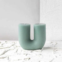 Black Blaze Curl Curl Sage candle with sculptural U-shape and ribbed texture, made from plant-based wax, unscented and decorative.