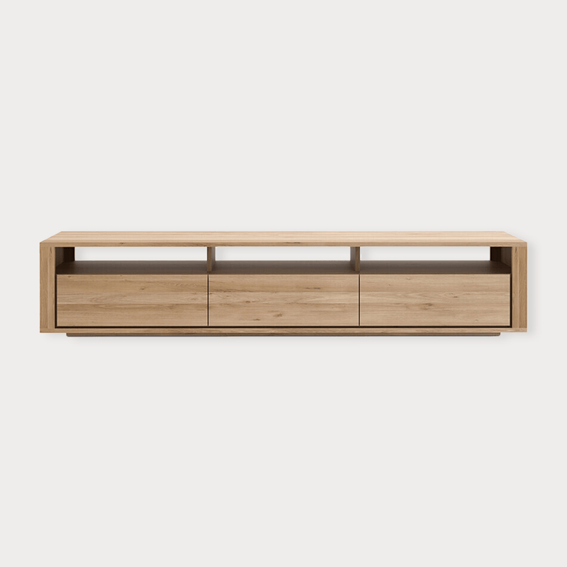 Ethnicraft Shadow TV Stand in natural oak with three drawers and open shelves, modern low-profile entertainment unit.