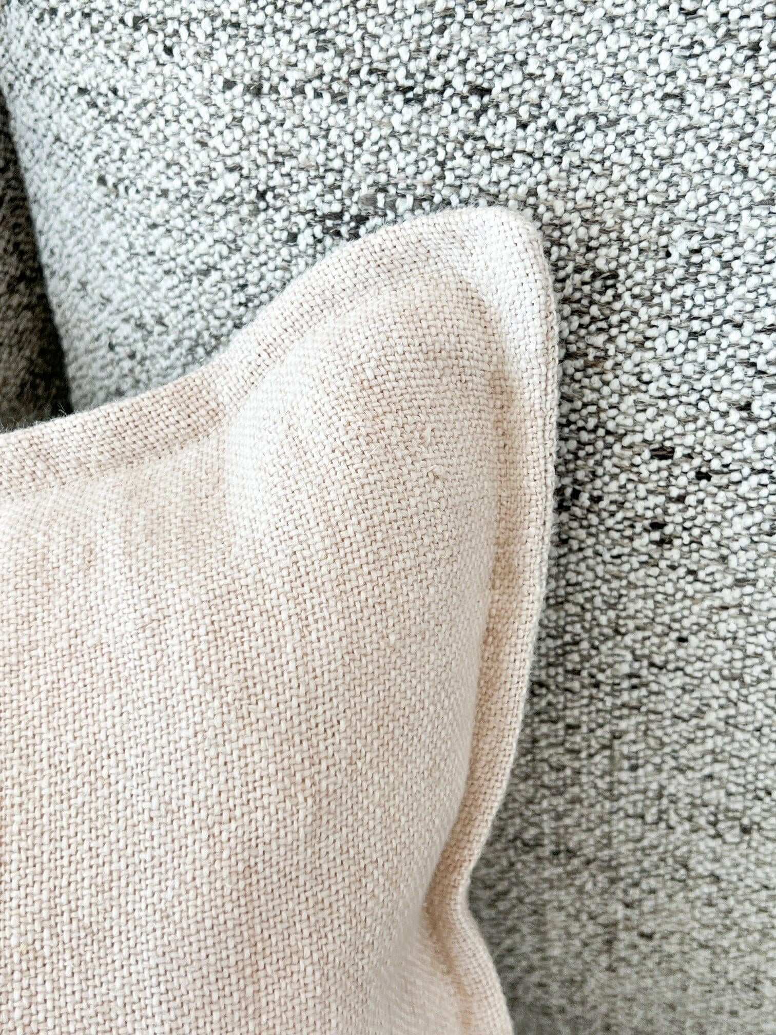 Baya Flaxmill Cushion in nude linen fabric with textured weave on a speckled grey background