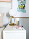 Dom Gauci Kids Art Print Sour Power wall art in a child's bedroom with bedside lamp and stacked books