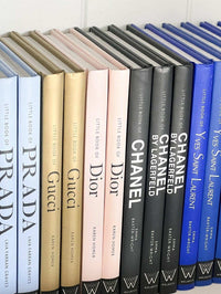 Collection of fashion monographs including The Little Book Of Chanel, featuring detailed hardcover designs in black, beige, blue, and white colors.