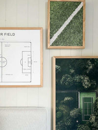 Set of three framed wall art prints featuring a soccer field diagram, a close-up green grass texture, and an aerial view of a tennis court surrounded by trees.