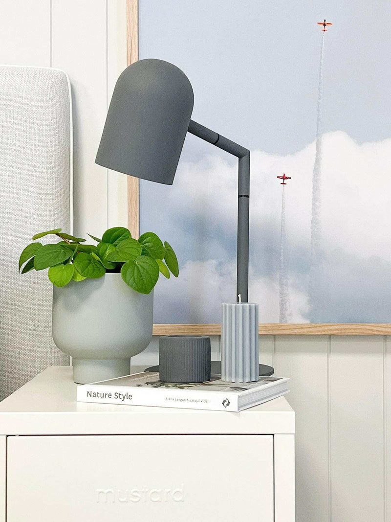 Charcoal Pia desk lamp with modern architectural design on bedside table.