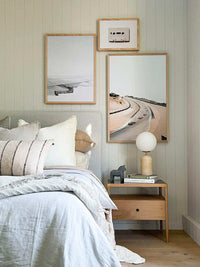 Soren Desk Lamp with travertine base, frosted glass shade, and brass details on wooden bedside table in modern bedroom setting