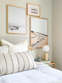 Wing Print photographic wall art in varying sizes displayed in a modern bedroom with neutral decor and a wooden bedside table.