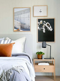 Modern Pia desk lamp in charcoal color on wooden bedside table in a contemporary bedroom setting