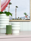 White porcelain Alder Pot with textured bubbly finish in various sizes on shelf with green plant and decorative items