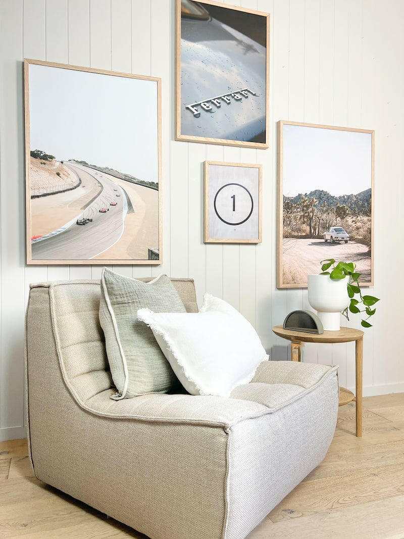 Dark beige Ethnicraft N701 single-seater sofa in a modern living room setting with framed wall art and side table with plant.