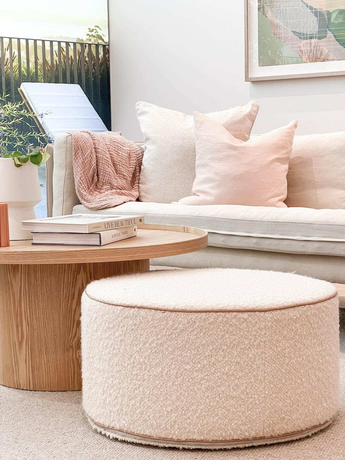 norsu Design Your Own Ottoman in soft blush boucle fabric with leather piping, styled in a modern living room setting
