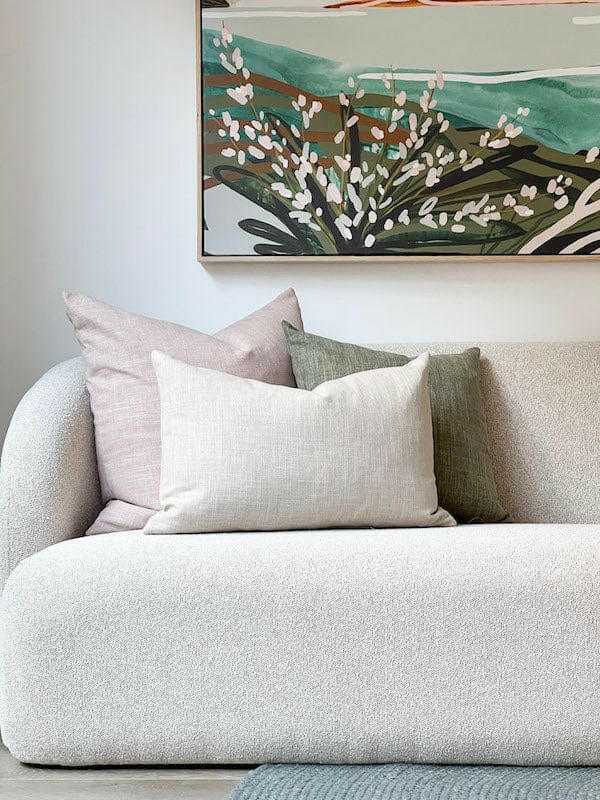 norsu Studio Washable Cushion in blush on white sofa with green and pink cushions and abstract wall art