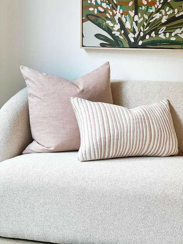 norsu Studio Washable Cushion in blush on beige sofa with floral wall art background