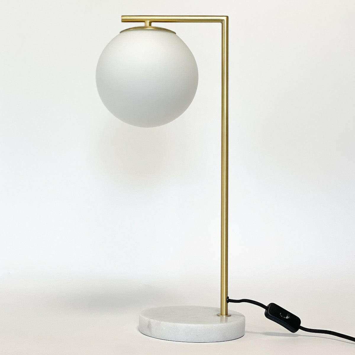 Remi Desk Lamp with antique brass finish, white marble base, and frosted glass globe shade in mid-century modern style
