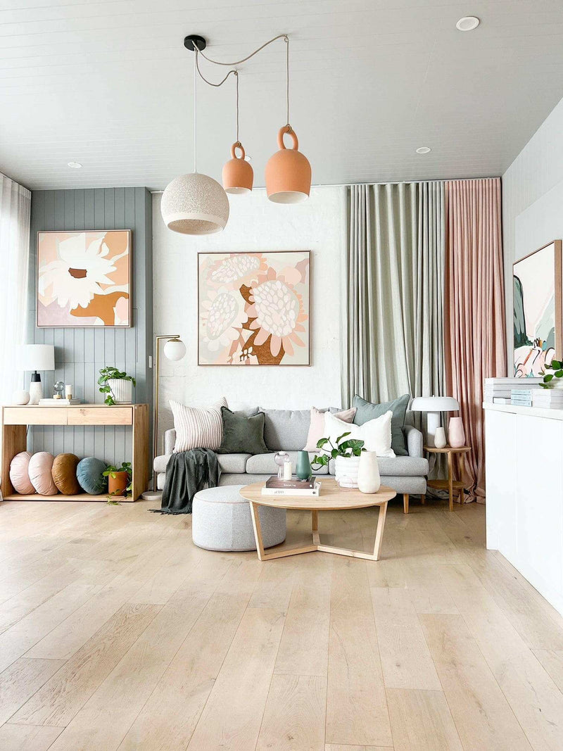 Modern living room with light wooden floors, pastel-colored curtains, soft cushions, and minimalist decor showcasing a stylish rug styling concept to get ready to meet your perfect rug match
