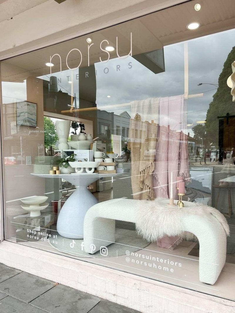 Zaru Boucle Bench seat in oatmeal with curved design and soft boucle fabric displayed in a modern interior store window