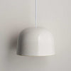 Robert Gordon Bell Light large white ceramic dome pendant light hanging against a plain wall