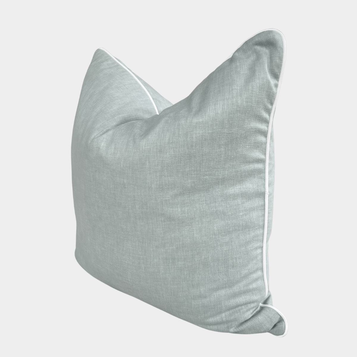 Soft light blue norsu Studio Cushion with white piping, handmade using high-quality Warwick fabric and feather down filling, available in various sizes.