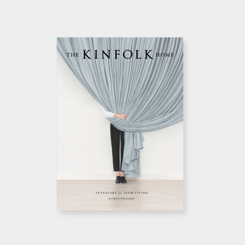 Cover of The Kinfolk Home book by Nathan Williams featuring a person partially hidden behind a large gray curtain, symbolizing interiors for slow living.