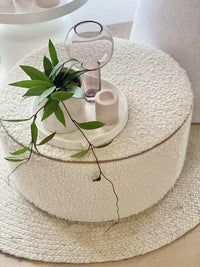 round white boucle fabric upholstered norsu design your own ottoman with blush leather piping and decorative tray on top