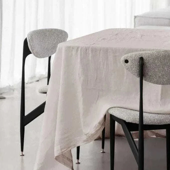100% linen natural tablecloth draped over dining table with modern chairs