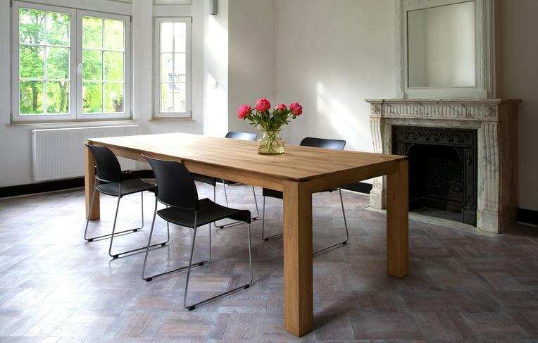 Natural oak Ethnicraft Slice extendable dining table with black chairs in bright room